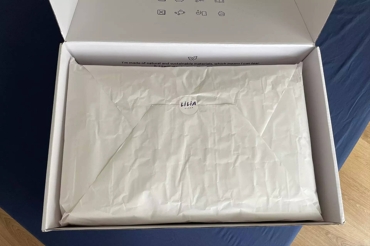 Caixa de cartão branca aberta com invólucro em papel no interior
