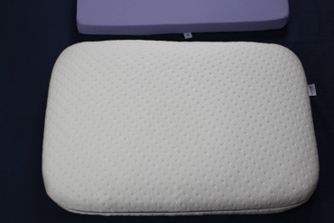Almofada de espuma branca ao lado das camadas roxas removidas do seu interior